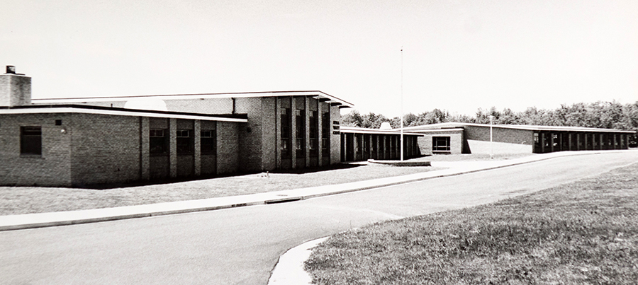 Black and white photograph of the front of Hybla Valley Elementary School facing Lockheed Boulevard taken in the late 1960s. The front of the building looks relatively the same as it does today, except the cafeteria section has been expanded. 